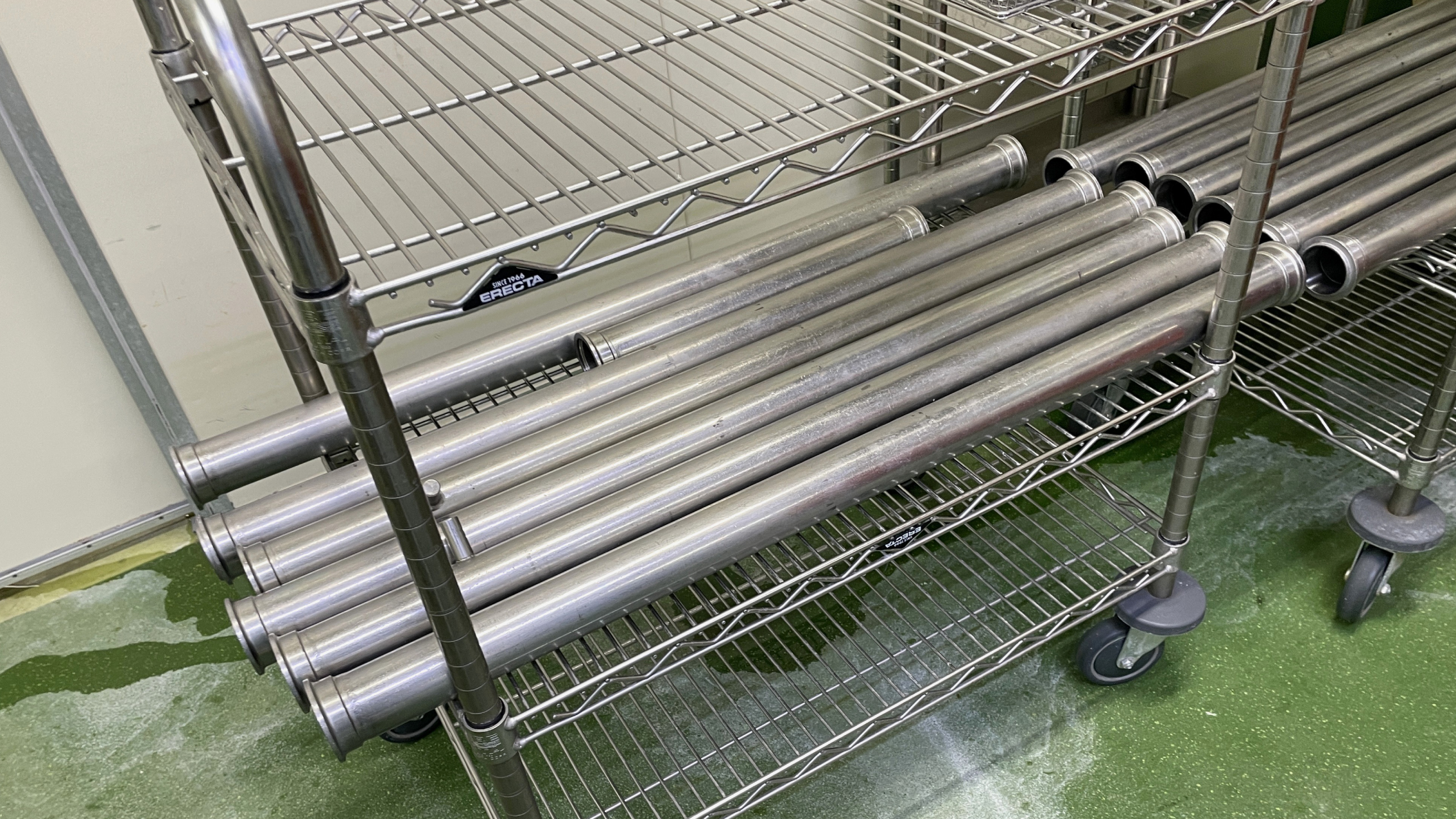 チーズが固着した従来のステンレス配管と手動洗浄作業