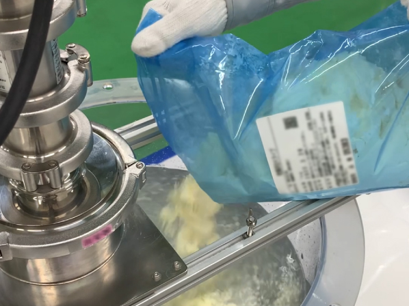撹拌タンクに粉体材料を投入しているイメージ
